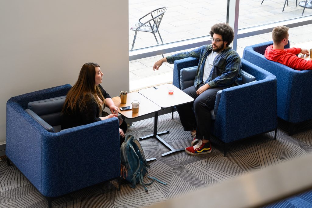 Students sitting across from each other talking 