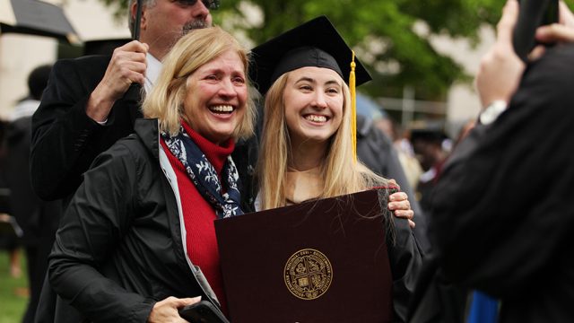 Graduate and guest smiling big for a picture