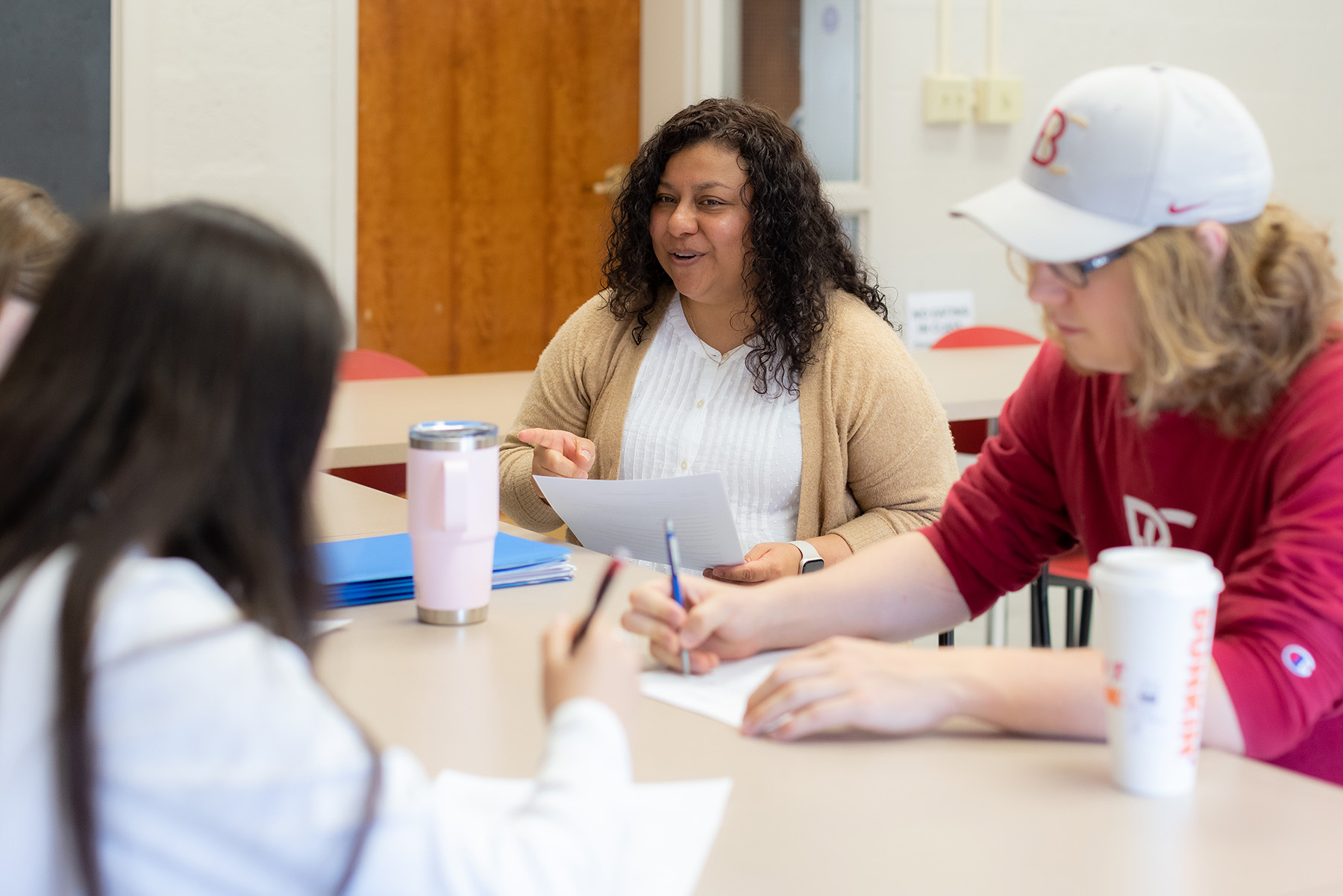 Professor sitting down and speaking with students