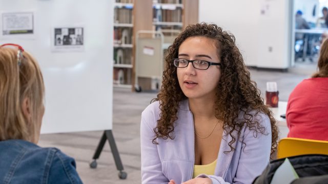 Student speaking to professor sitting across from them