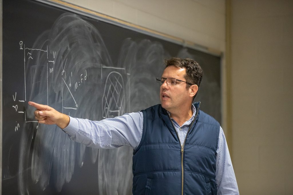 Professor Derli Amaral points to a chalkboard during a foundations of engineering class