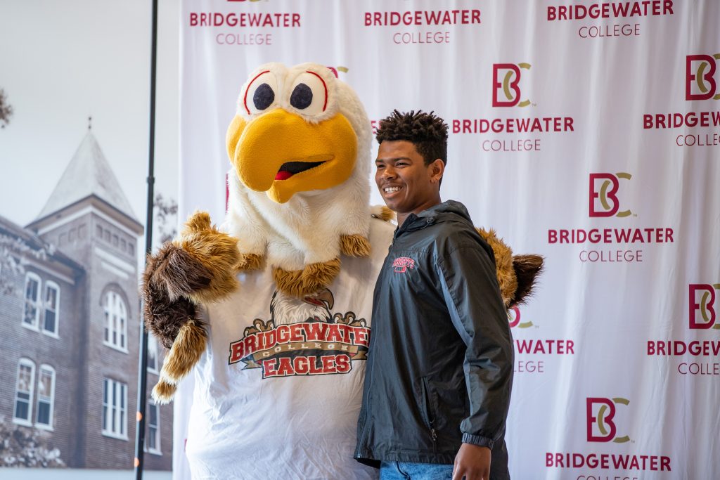 Prospective student standing with mascot, Ernie for a picture