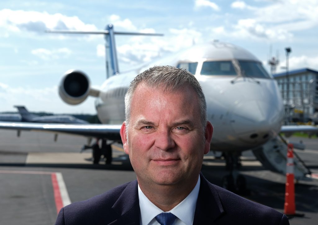 Greg Campbell standing in front of an airplane.