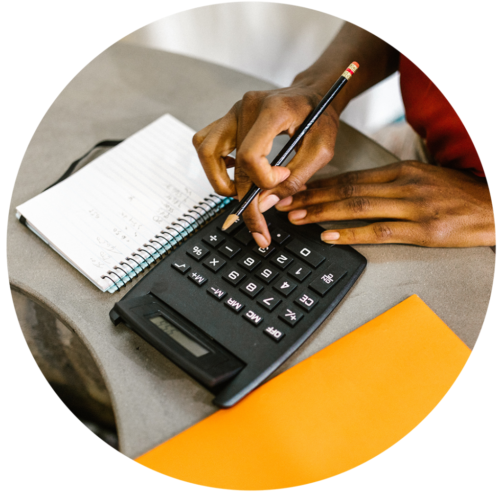 close up of hands typing on calculator 