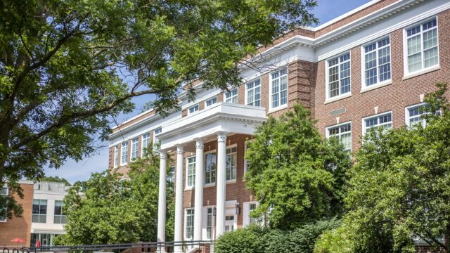 Bowman Hall at Bridgewater College on a bright sunny day surrounded by green trees and bushes