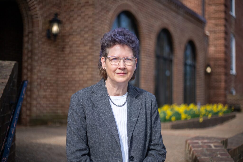 Cynthia Howdyshell-Shull standing in front of a brick building smiling.