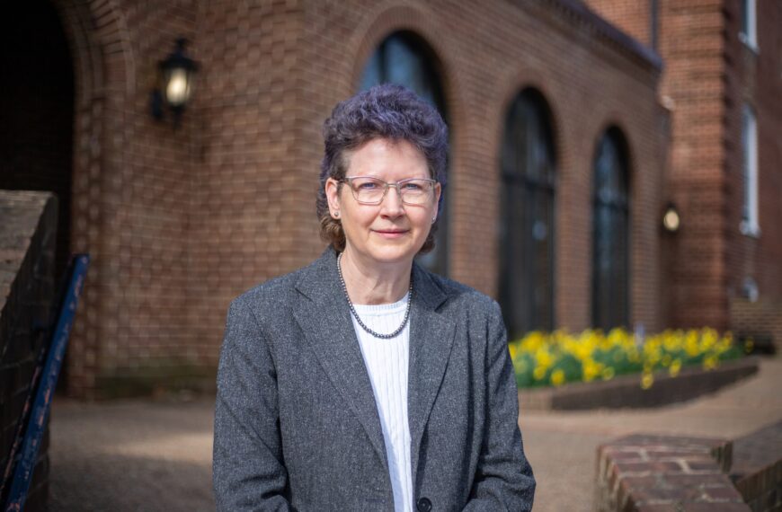 Cynthia Howdyshell-Shull standing in front of a brick building smiling.