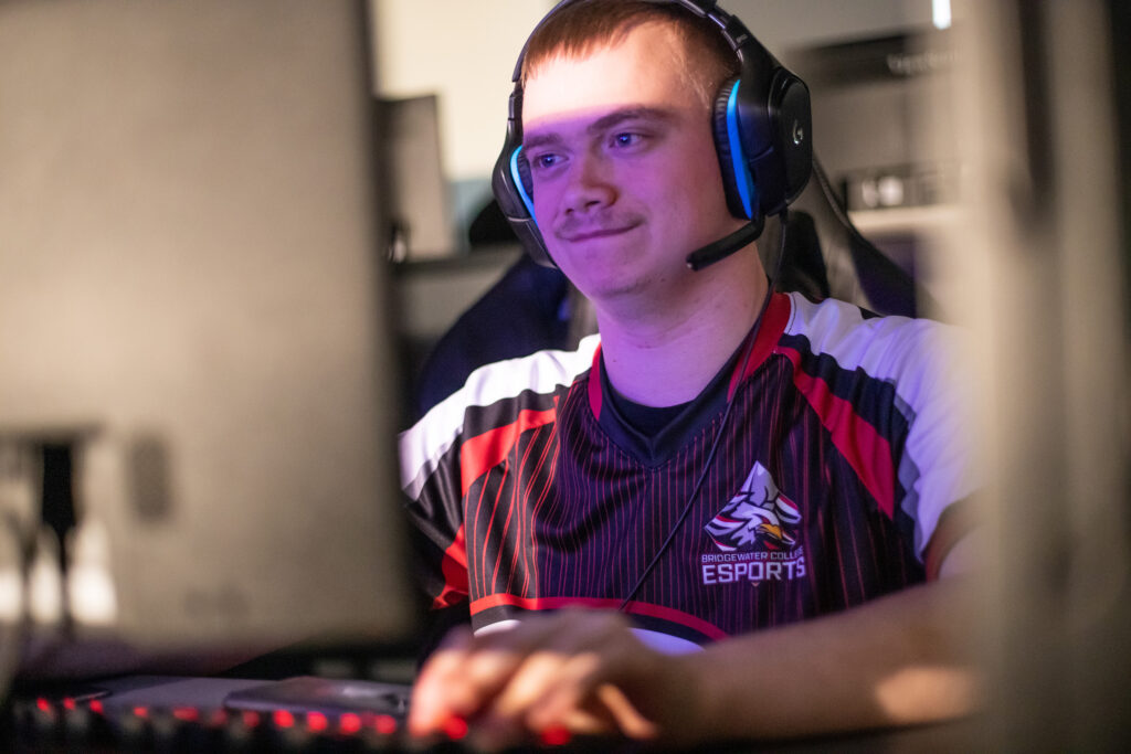 Student sitting at computer with headphones on participating in esports