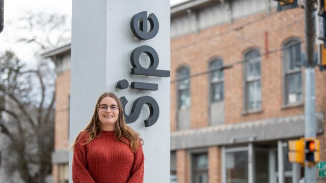 MaryBeth Killian standing outside in front of a sign that says Sipe