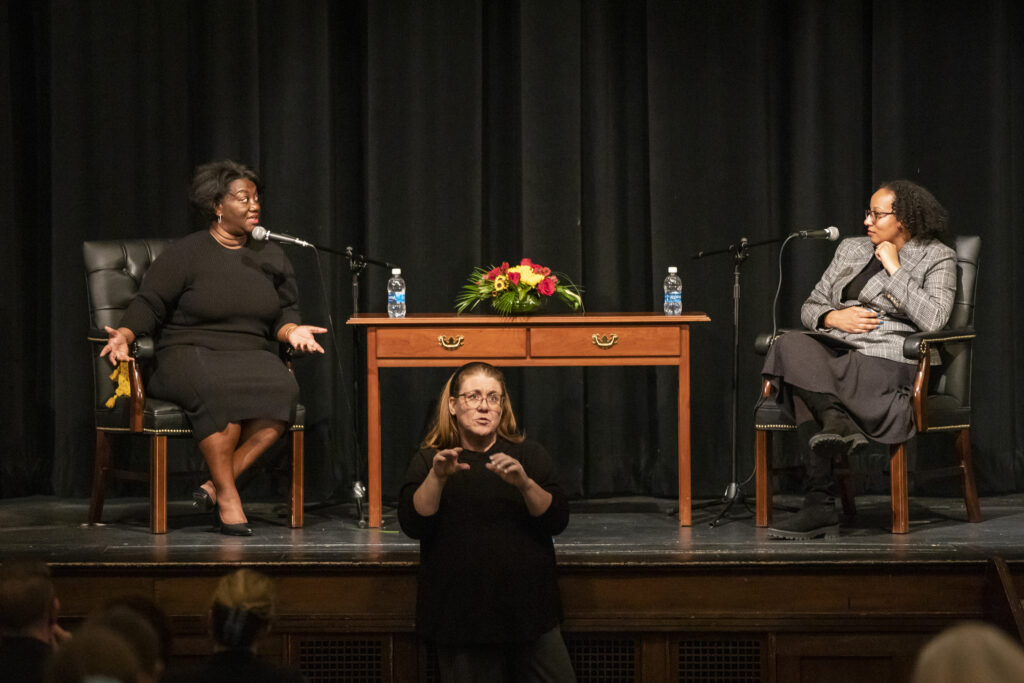 Dr. Tressie McMillan Cottom and moderator Dr. Dominique Baker on stage at endowed lecture with sign language interpreter in front