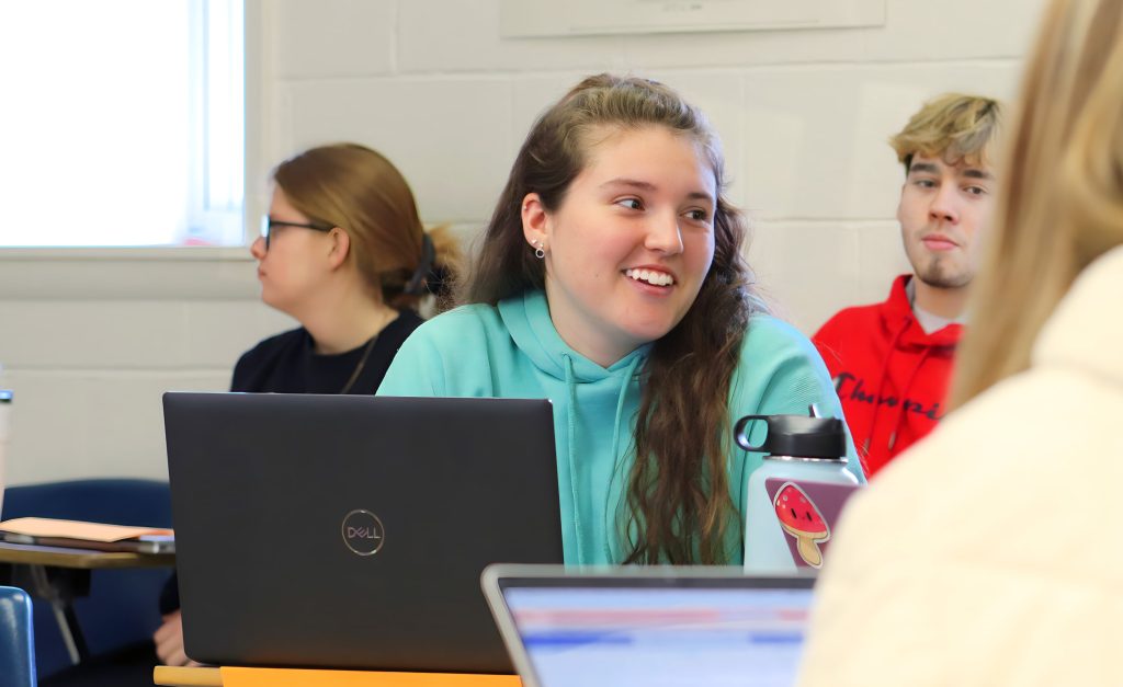 A teacher education student converses with her peers to discuss material in their Educational Psychology class. 