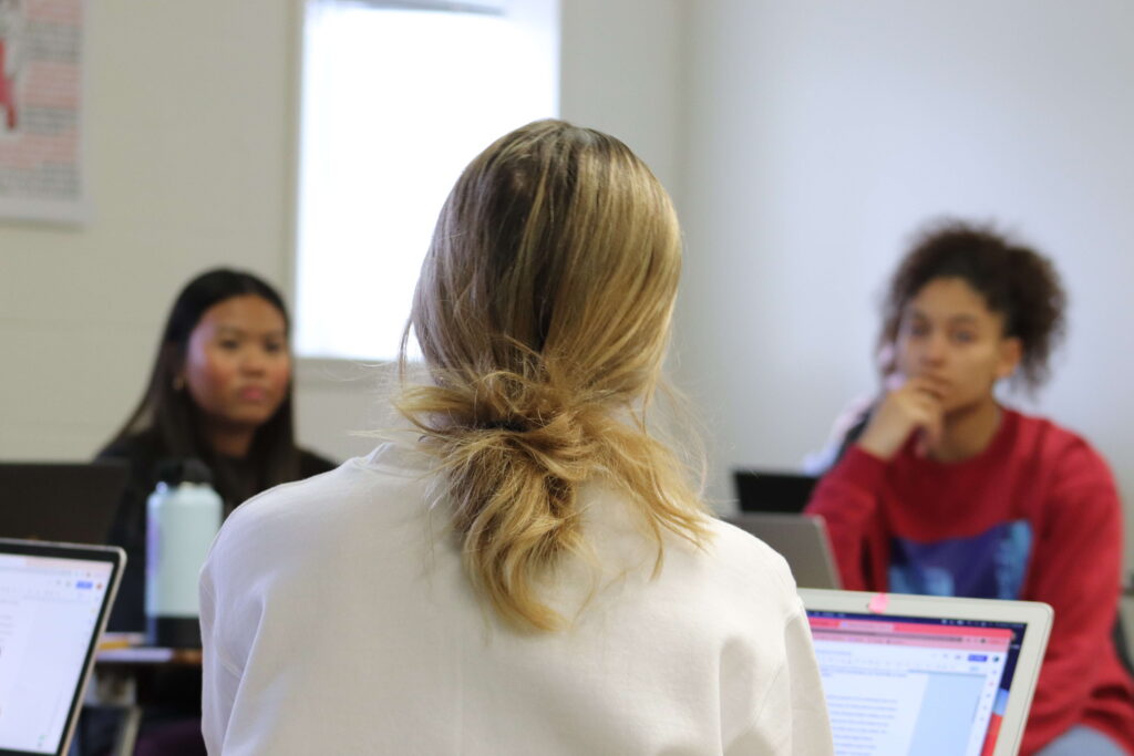 Two students listen carefully to one of their peers in their Educational Psychology class.