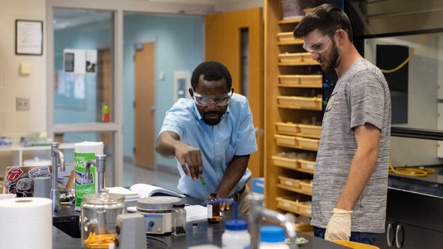 Professors using chemistry lab equipment with student