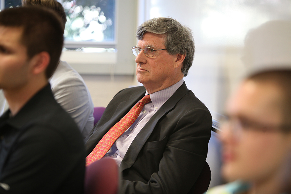 Man wearing suit and tie paying attention in class