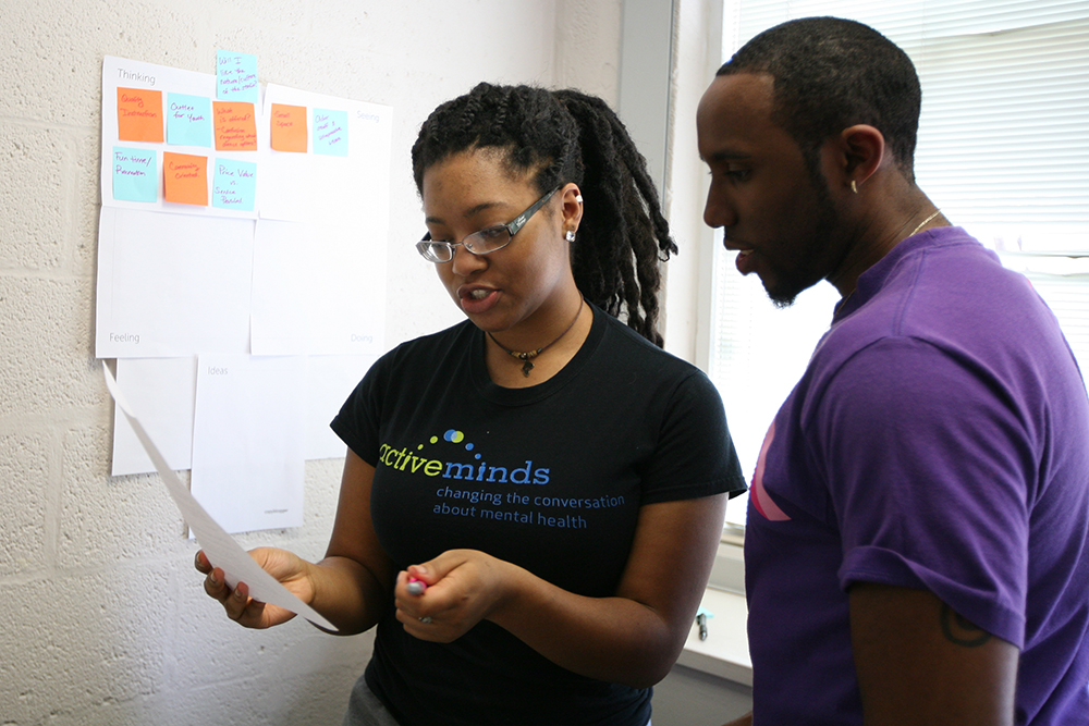 Student wearing an active minds t-shirt working with another student during class