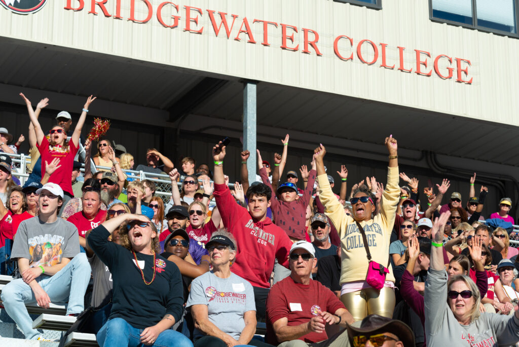 Crowd standing and cheering at football game