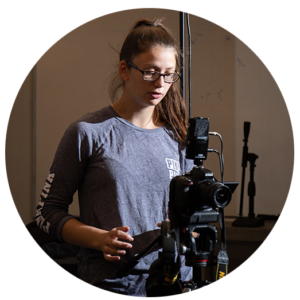 Student in studio working with camera equipment