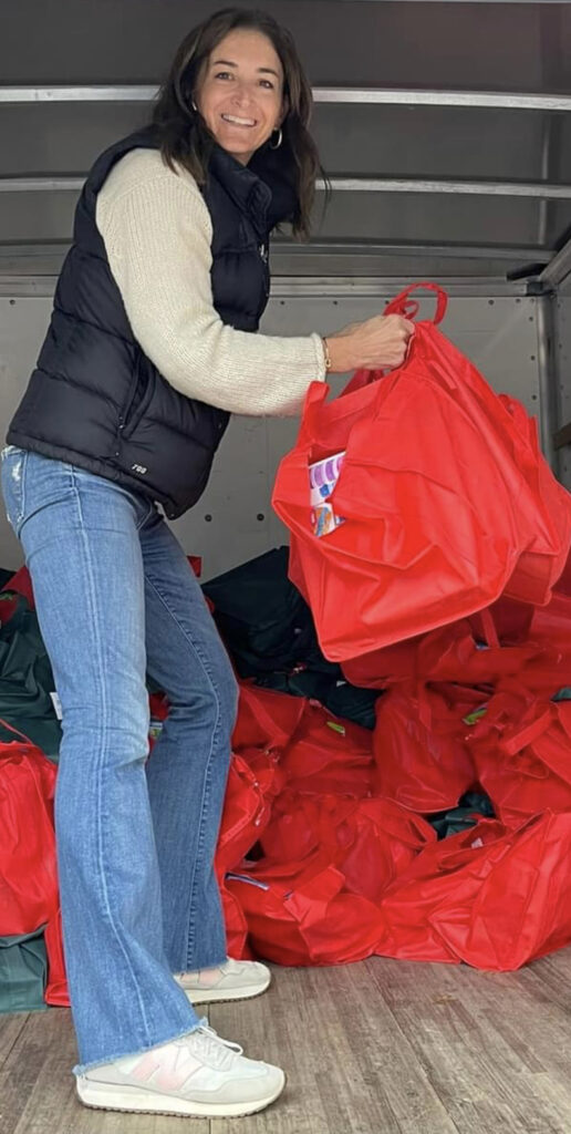 Taryn Lloyd unloads bags from a truck for the Caring Carver Holiday Gift
