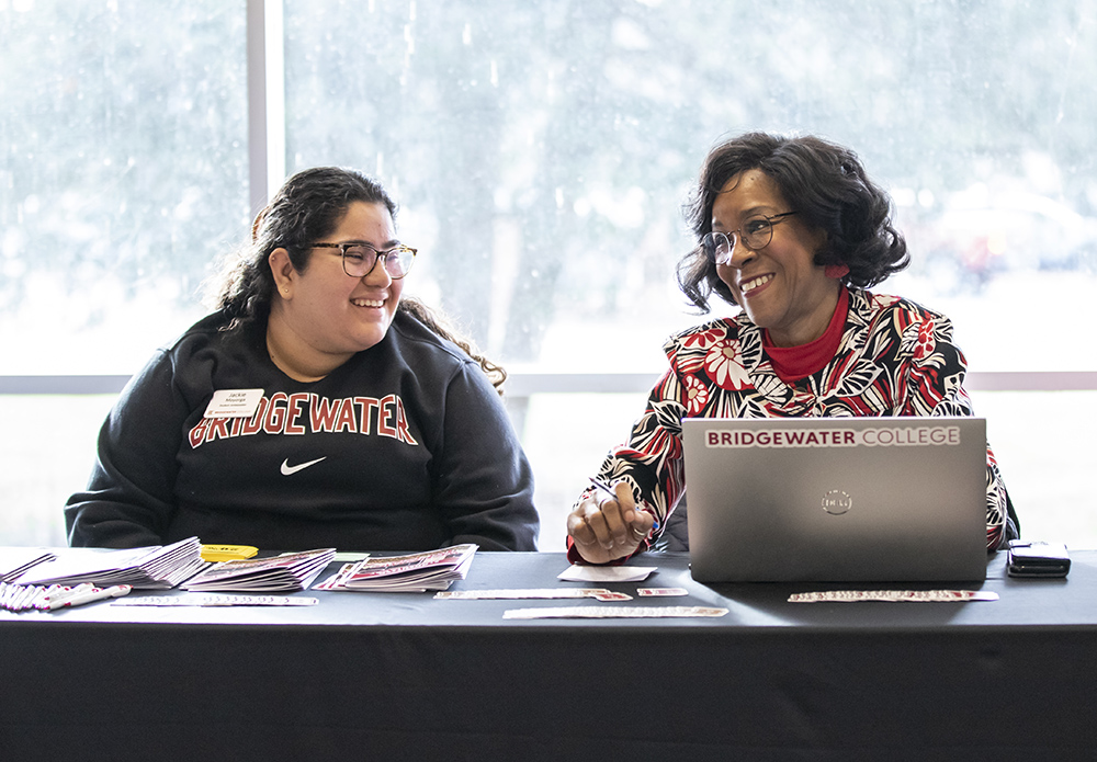 Staff member working with student at an admissions event