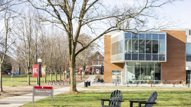 Adirondack chairs sitting on the lawn with the Forrer Learning Commons in the background