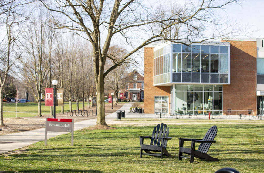 Adirondack chairs sitting on the lawn with the Forrer Learning Commons in the background