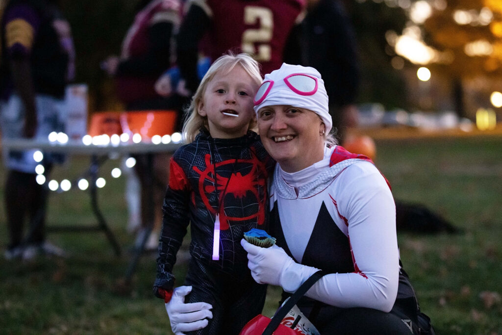 Staff member and child dressed up for Halloween at community Halloween event