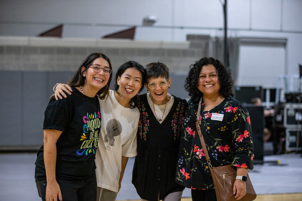 Four staff members posing for photo at Salsa night