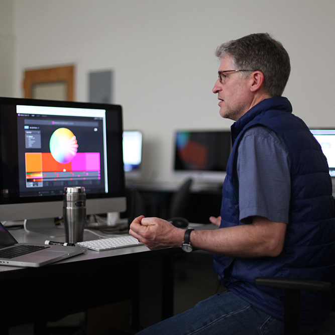 Person working at computer with colorful image on the screen