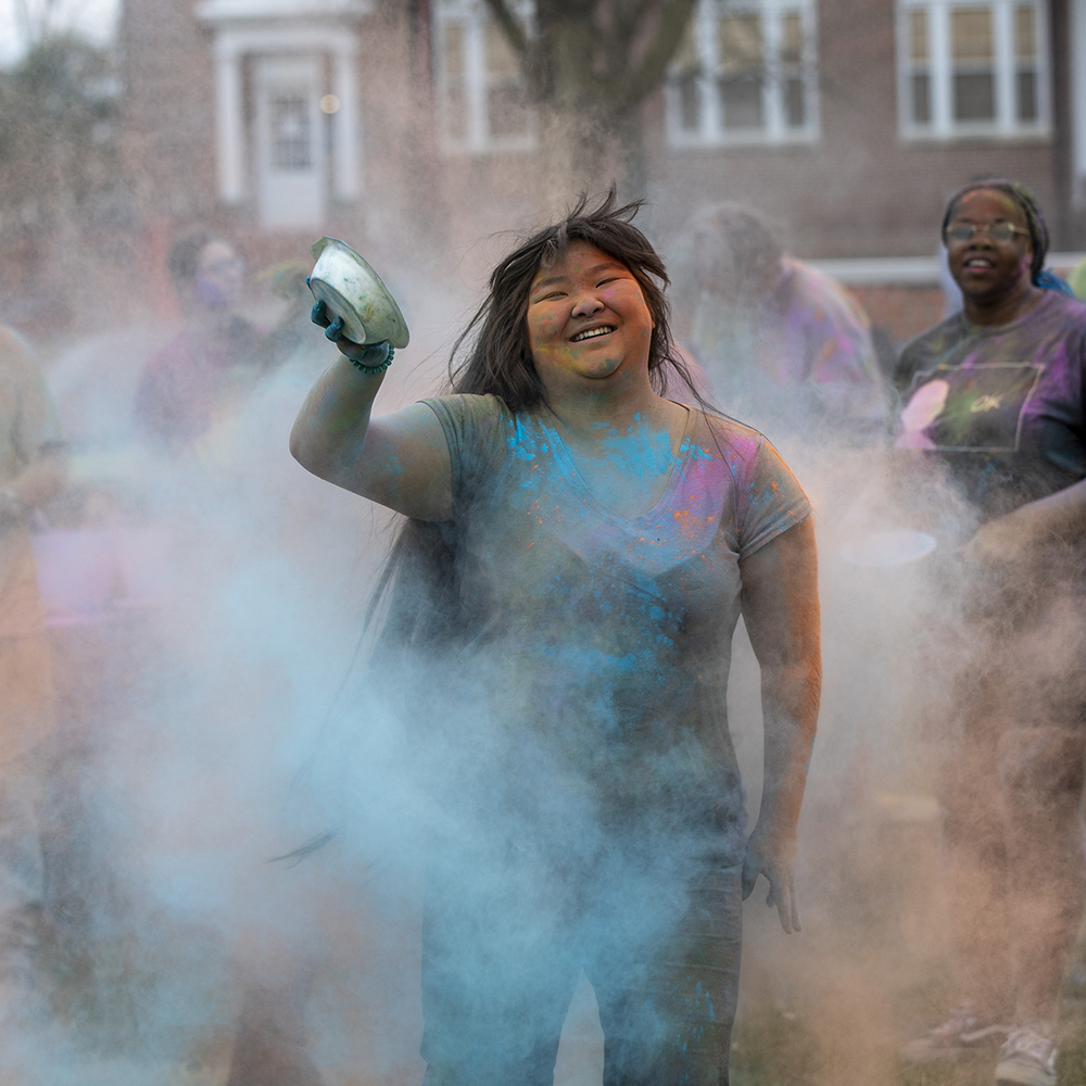 Student covered in blue powder during Holi celebration