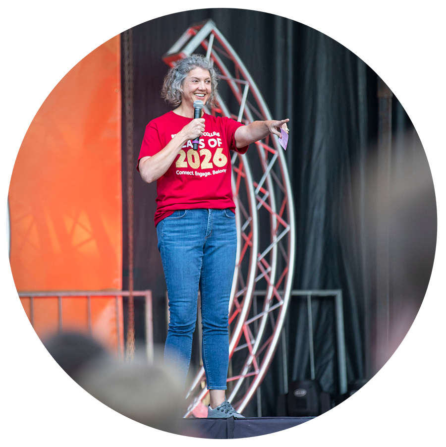 Dean of students, Leslie Frere on stage at an event pointing at the crowd