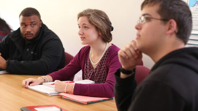 Three students paying attention in a class