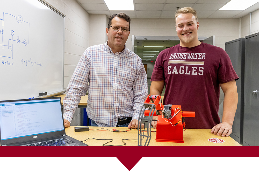 Cameron Martindale and Dr. Amaral standing behind their project: a self-stabilizing supernumerary leg.