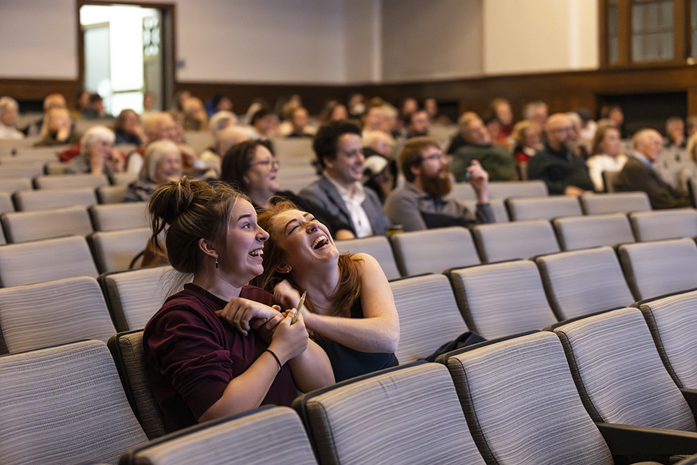 Members of the crowd laughing at Alexandra Petri's humor during her lecture