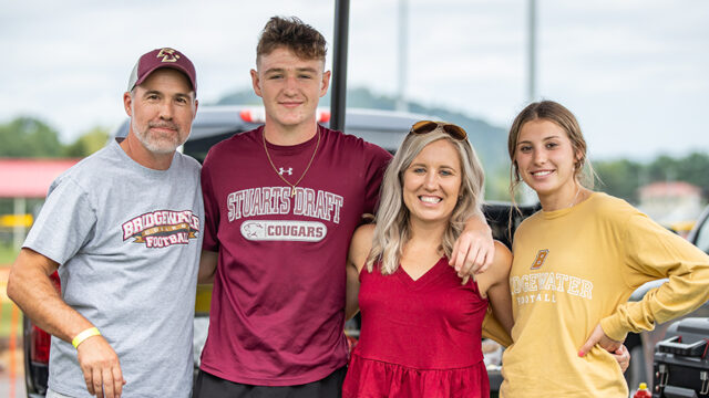 Family of four wearing Bridgewater shirts posing for a picture