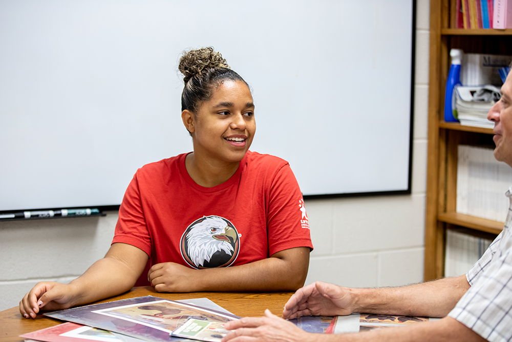 Student wearing red shirt with athletic Eagle logo 