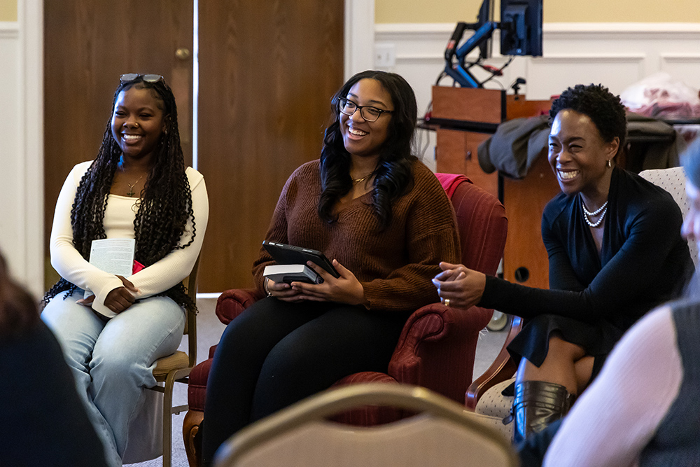 Three women sitting in chair smiling