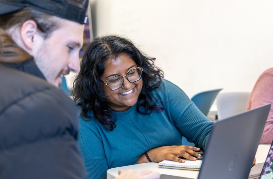 Two students looking at a laptop