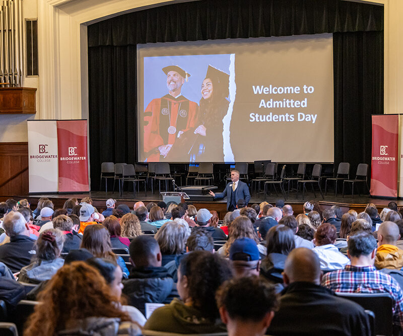 Cole Hall full of people during Admitted Students Day with the projector screen reading Welcome to Admitted Students Day