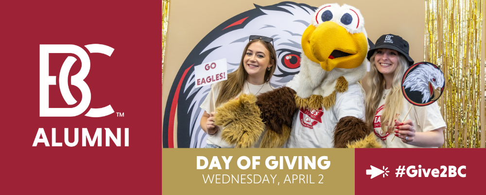 Bridgewater College alumni pose with the BC Eagle mascot at a festive event Two women wearing BC Alumni shirts and accessories smile while holding signs that say Go Eagles and feature the eagle logo The background is decorated with gold streamers and a large eagle graphic The image promotes Bridgewater Colleges Day of Giving on Wednesday April 2 with the hashtag Give2BC