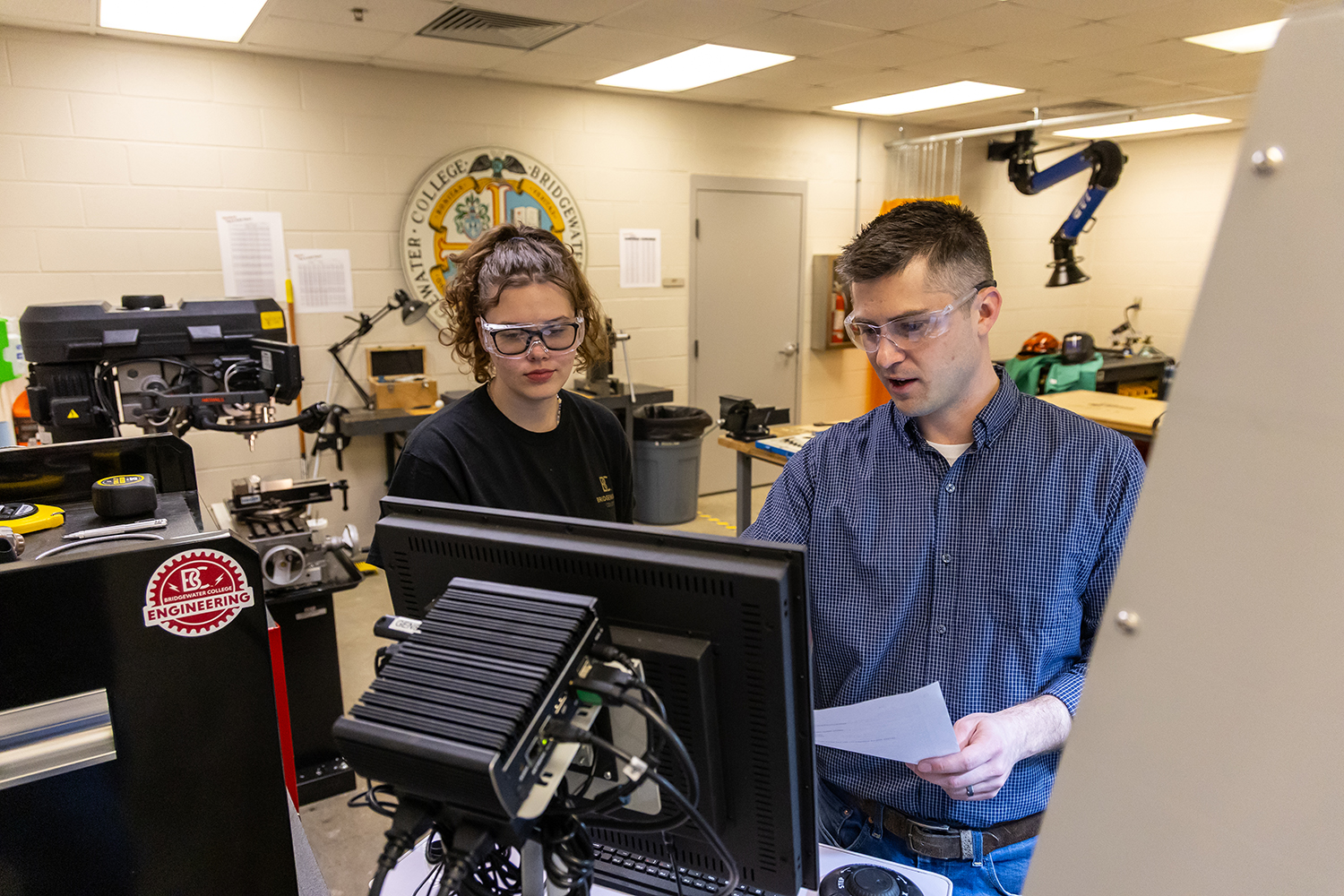 Engineering student working with lab manager on equipment
