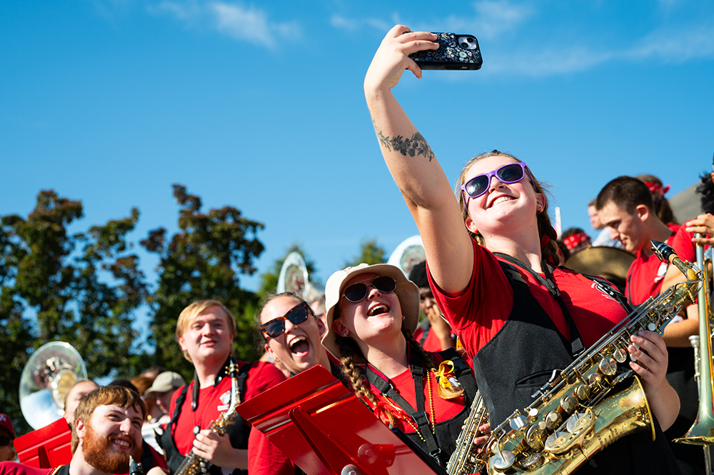 Members of B-C marching band talking a selfie in the football stands