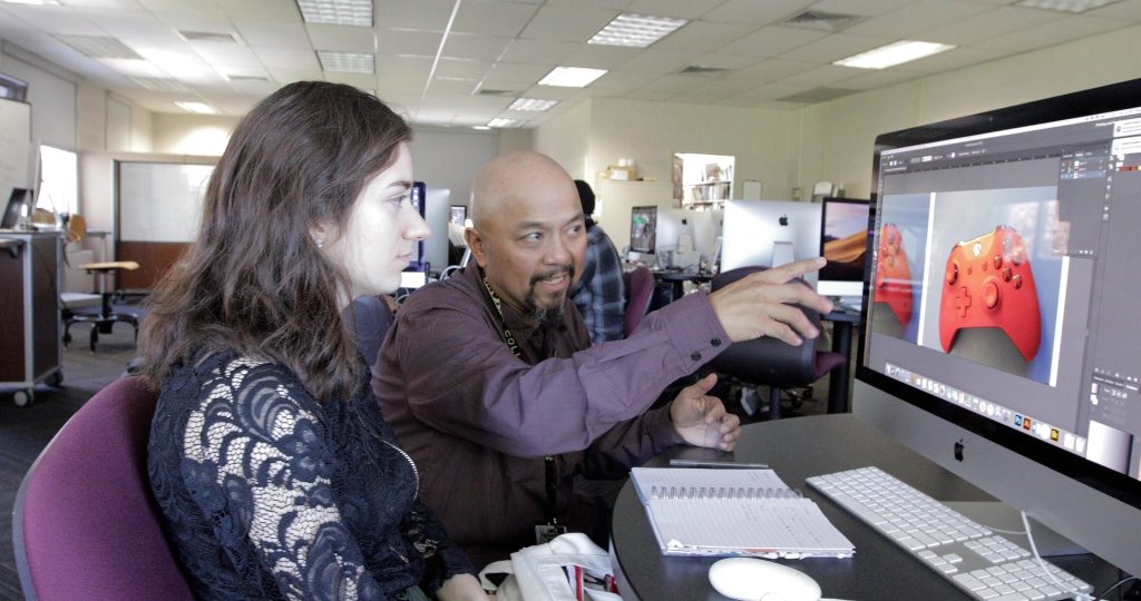Professor pointing to computer with a picture of a red video game controller displayed on the screen
