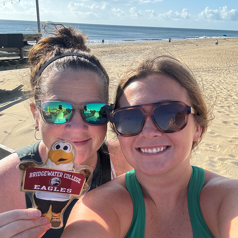 Ladies with sunglasses holding  Flat Ernie for a picture at the beach