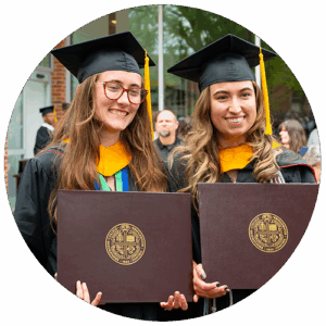 Two graduates holding up their diplomas at commencement