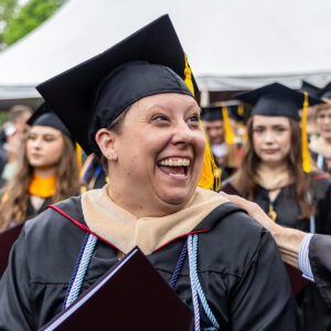 Graduate at commencent  smiling big and looking excited