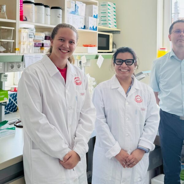 Student and faculty in lab smiling and posing