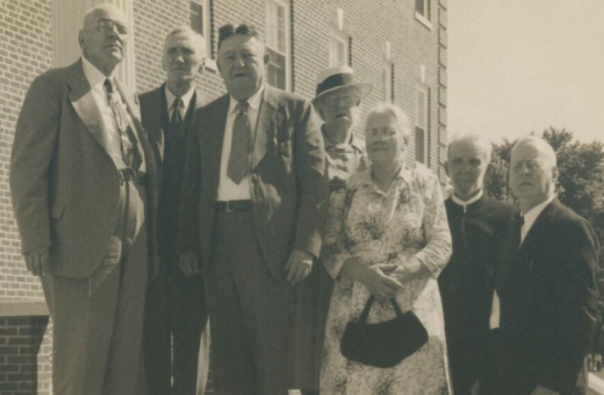 Group of seven alumni from the Class of 1899 standing on stairs.