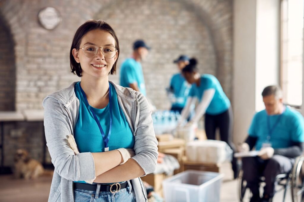 A woman stands confidently for a portrait at a food pantry she works at