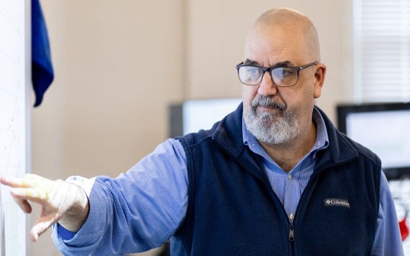 Professor Skip Burzamato points to a screen while giving a presentation