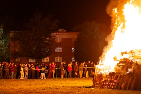 giant fire with a large group of people standing dozens of feet away to not get burned